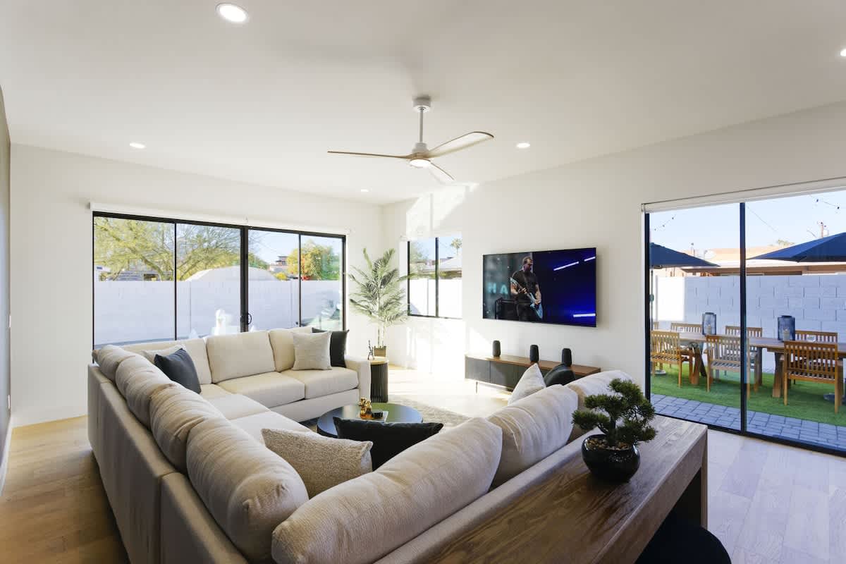 Main living area featuring designer furnishings, a Smart TV, and access to the backyard.