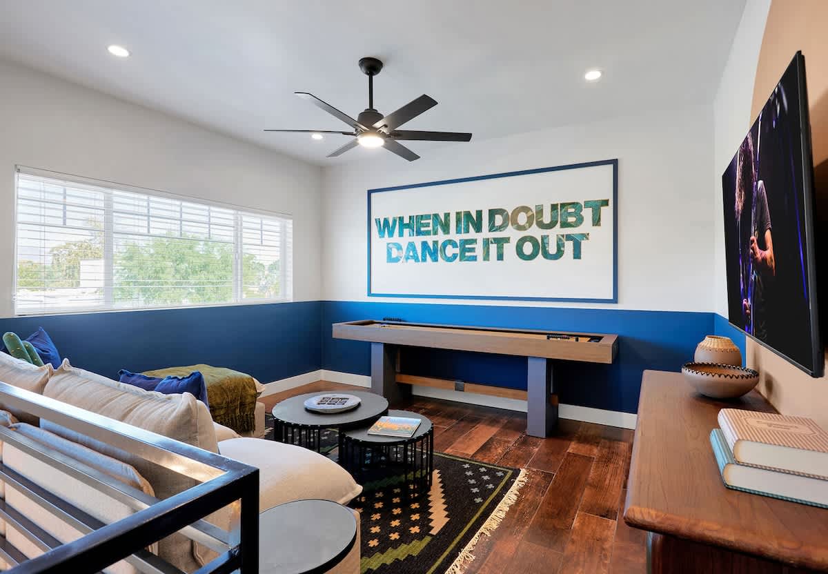 The second living area is an inviting upstairs loft featuring a cozy sectional, shuffleboard, a smart TV, and a selection of board games for laid-back fun.