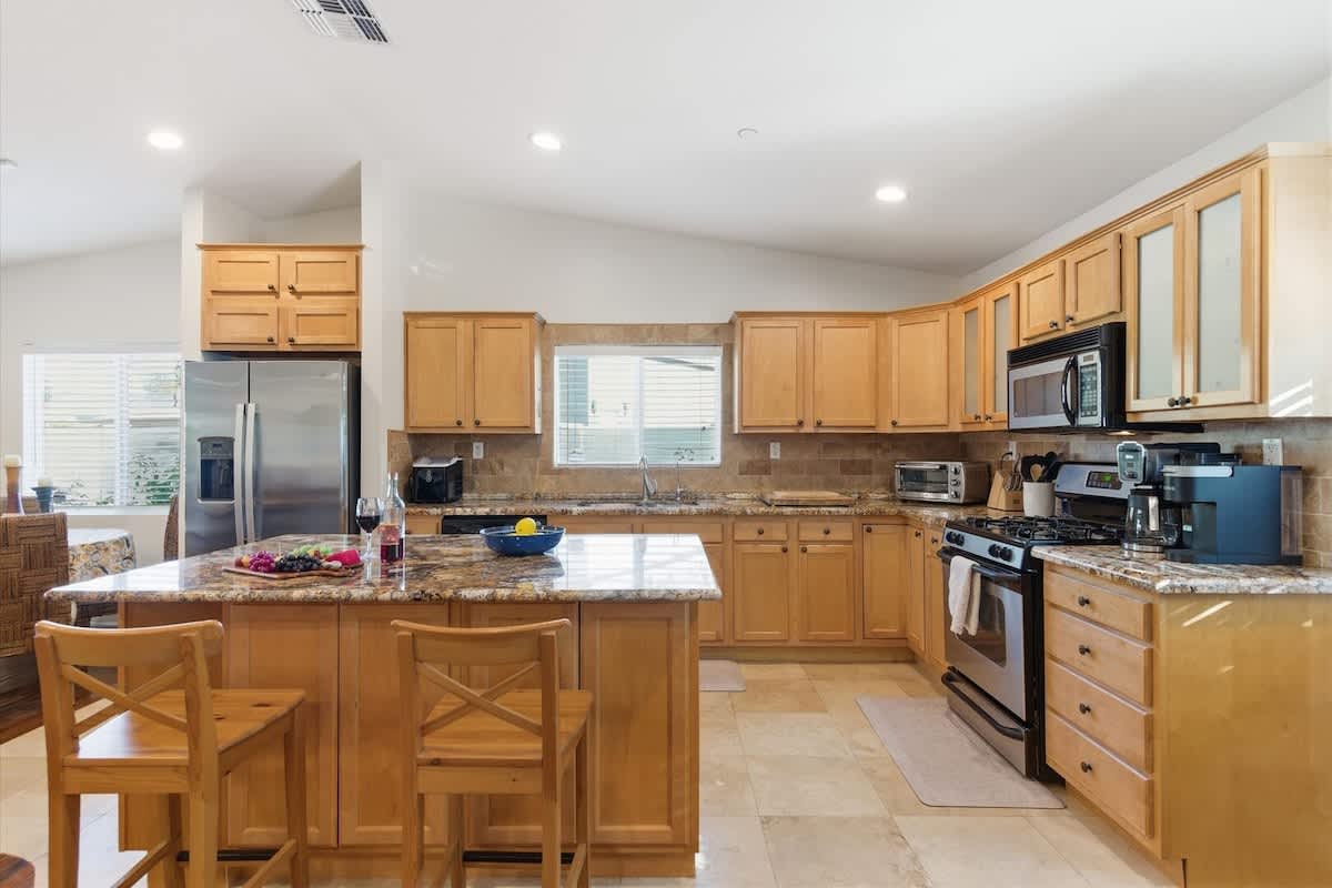 Fully equipped kitchen with stainless steal appliances and a kitchen island with bar seating for 2 guests.