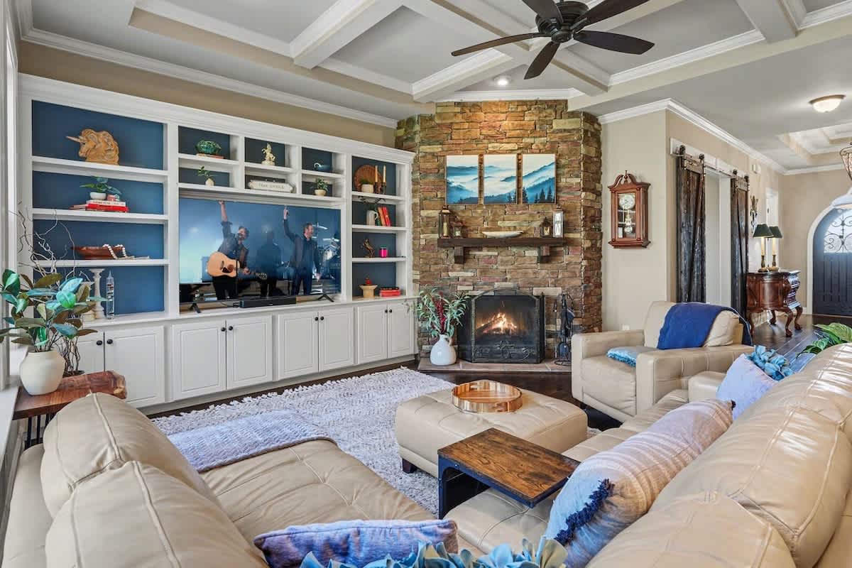 Main living area featuring a smart TV, cozy furnishings, a fireplace, and access to the backyard.