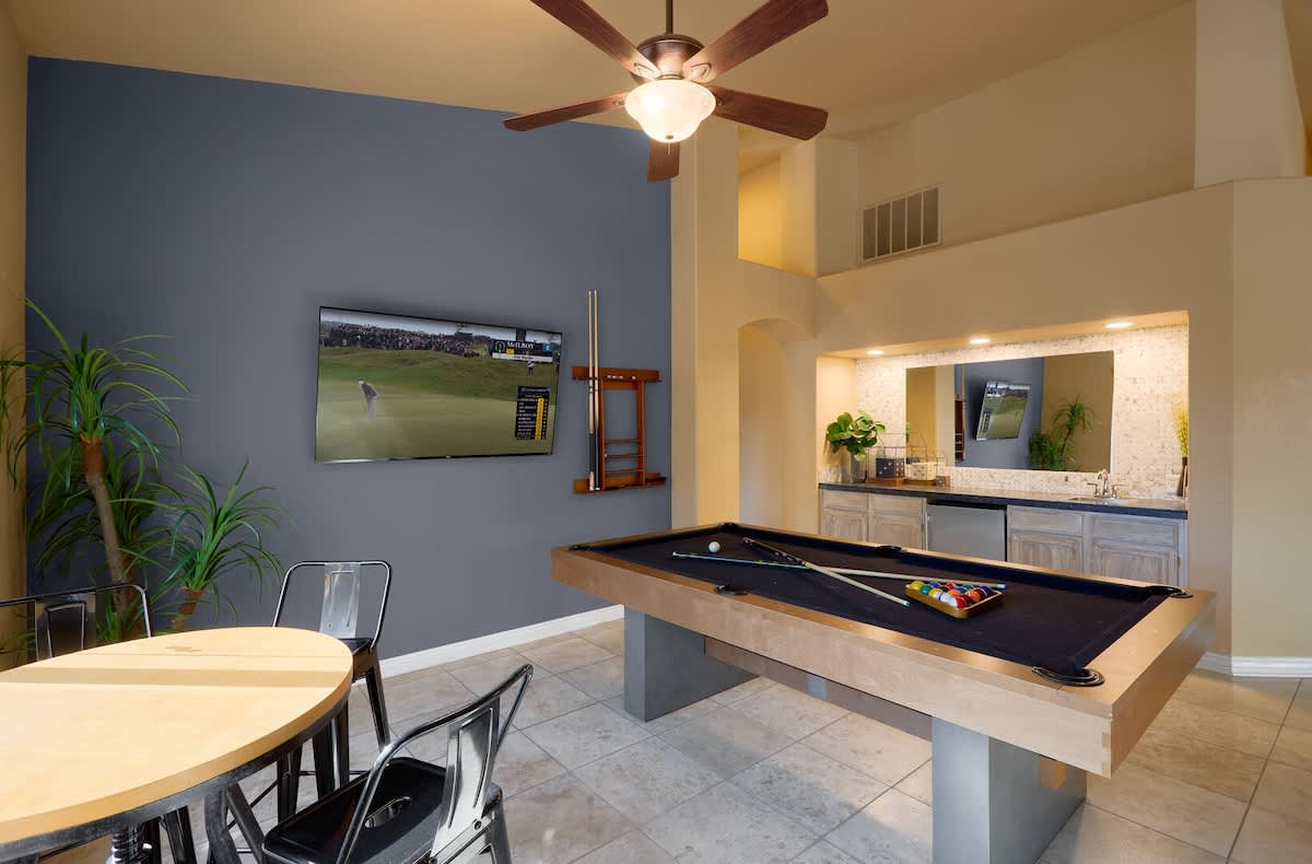 Game room with a pool table, smart TV, wet bar, and small dining area with seating for 4 guests.