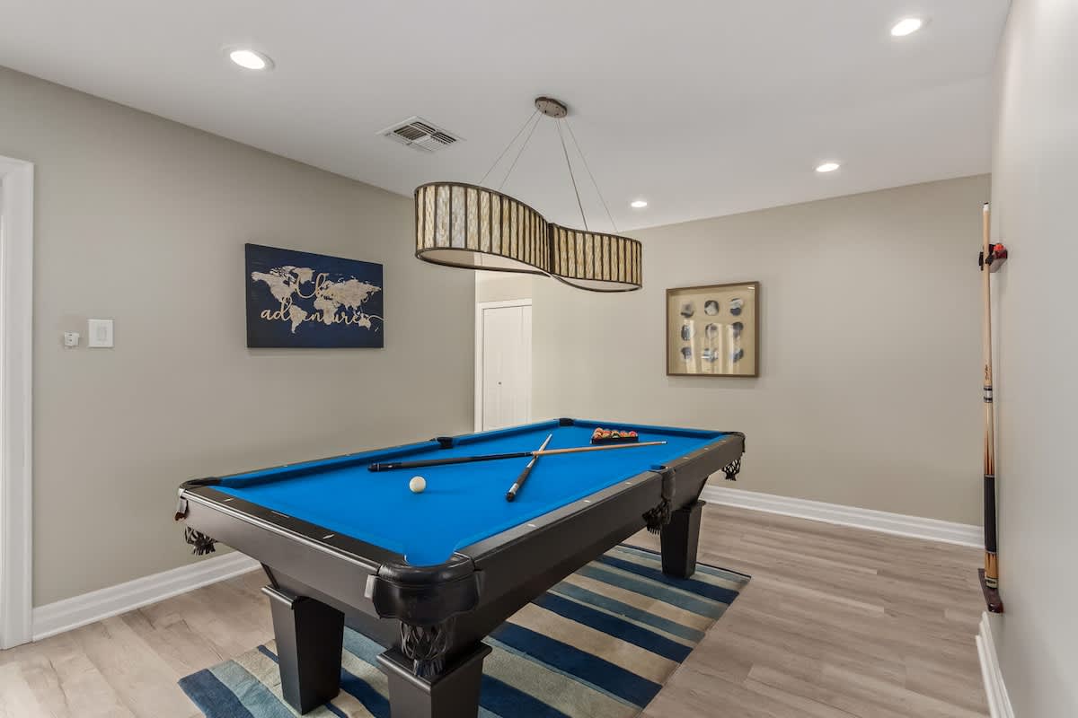 Spacious designer furnished living room featuring a Smart TV, Sound system, and a Pool table for entertainment.