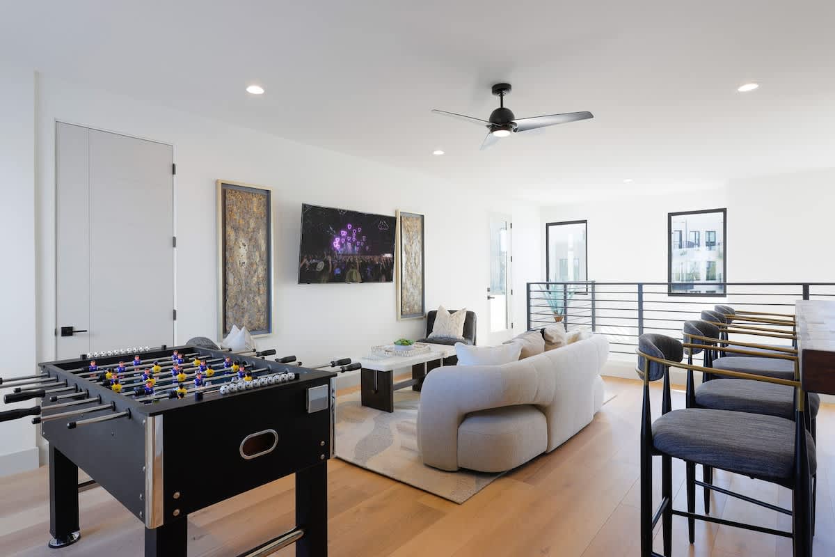 2nd living/game room with bar seating for 4, designer furnishings, smart TV, foosball table, and metal dartboard. (2nd Floor)