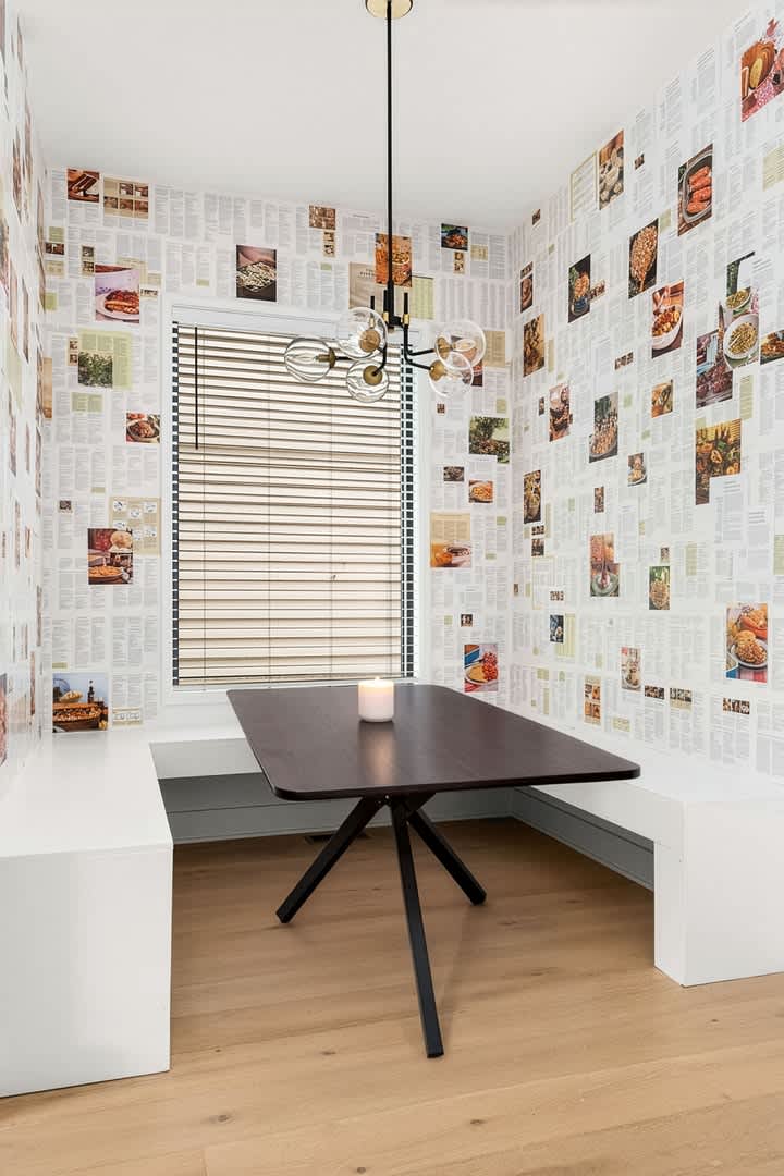 Inviting dining nook with built-in bench seating, a sleek modern table, and statement wallpaper. (1st Floor)