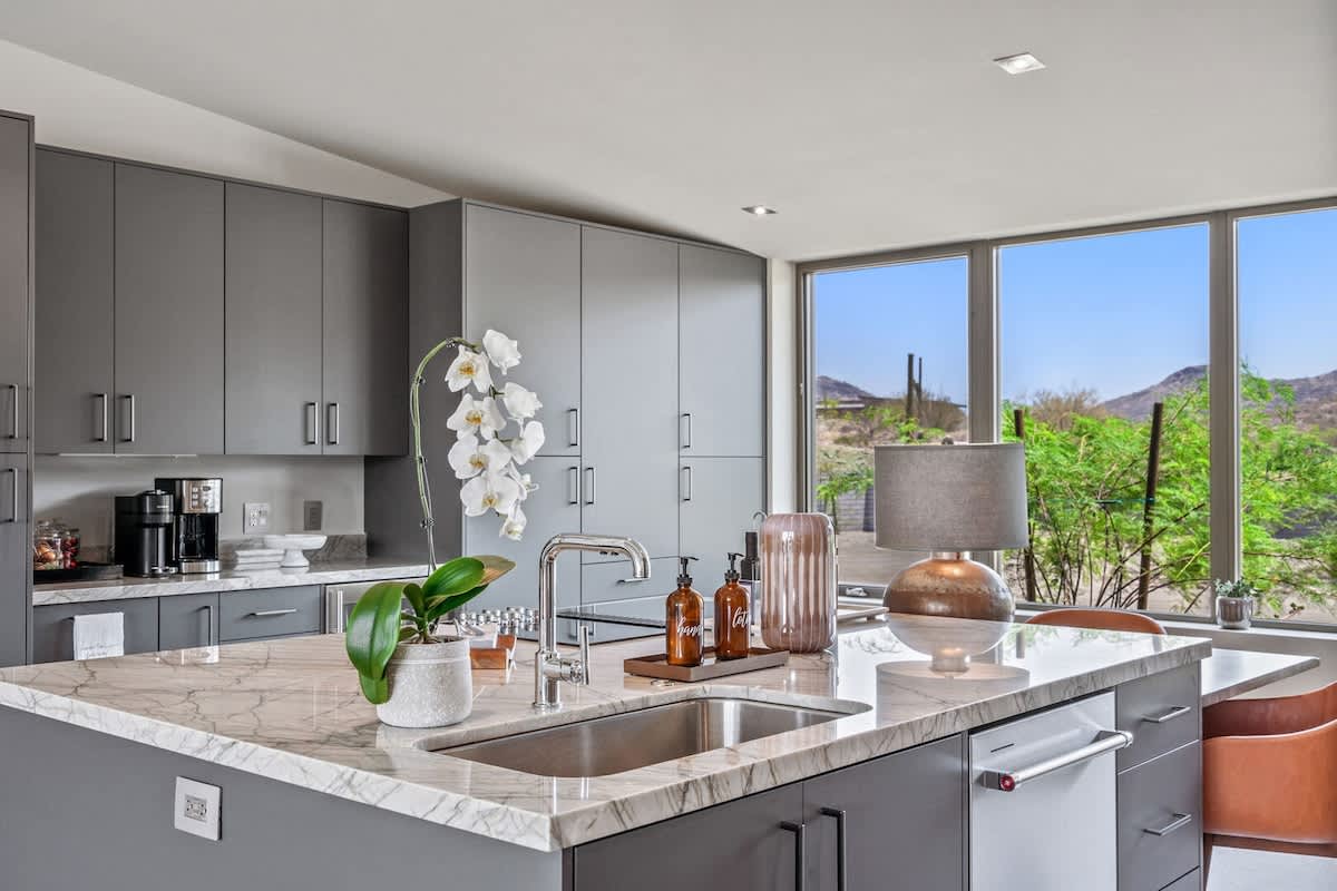 Estate 1 - Fully equipped luxury kitchen stocked with all culinary essentials and features high-end stainless-steel appliances, a kitchen island, a breakfast table, and a wet bar/coffee station.