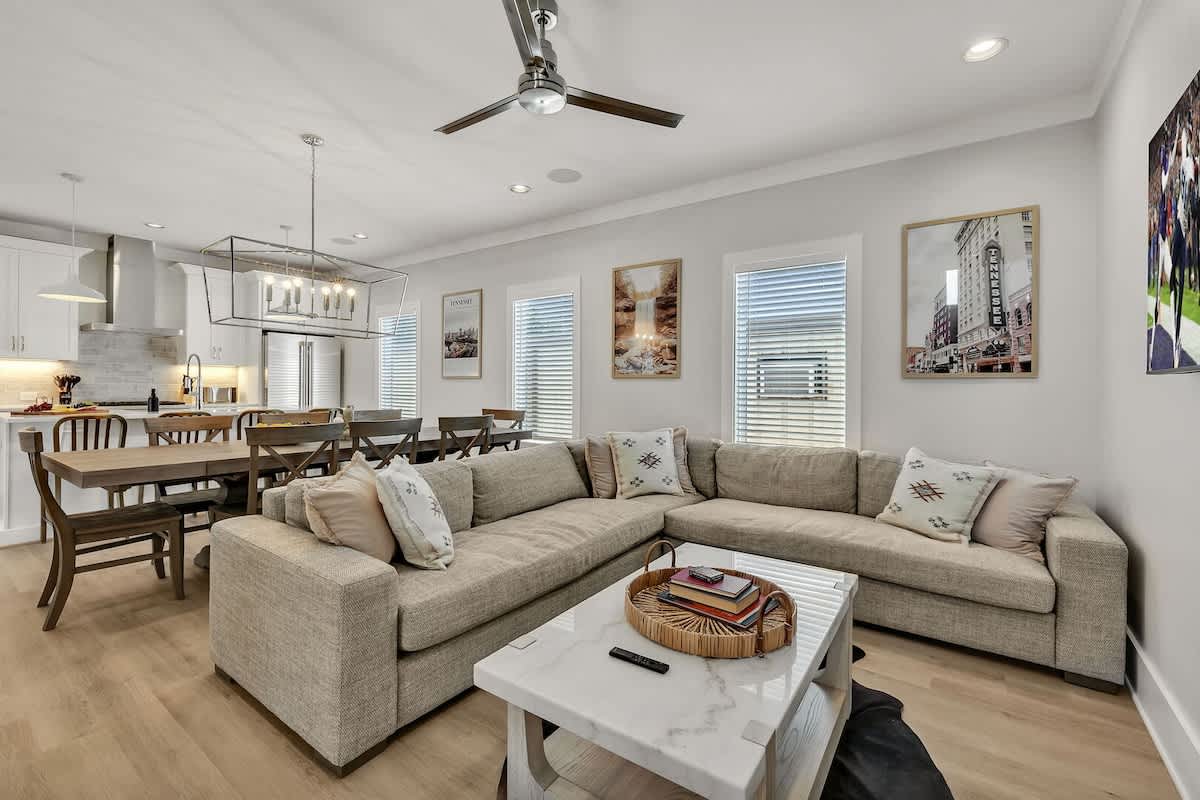 Unit 2 - 2nd Floor: Warm and inviting open-concept living space seamlessly flowing the designer furnished living room with the fully equipped kitchen and dining area.
