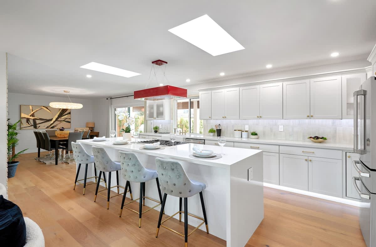 Fully equipped kitchen with stainless steal appliances, LED lighting, and a kitchen island with bar seating for 4 guests.
