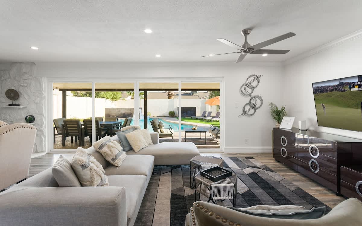 Living area featuring designer furnishings, a Smart TV, pool table, and access to the backyard.