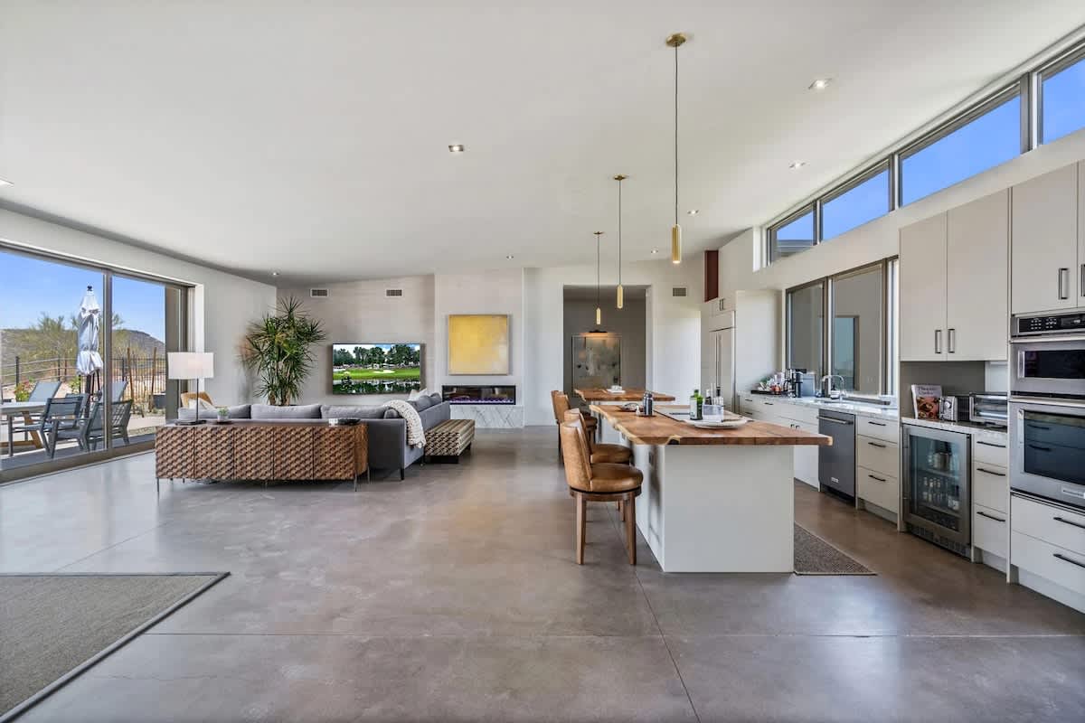 Spacious, light, and bright living room featuring an electric fireplace, wet bar, Smart TV, and designer furnishings.