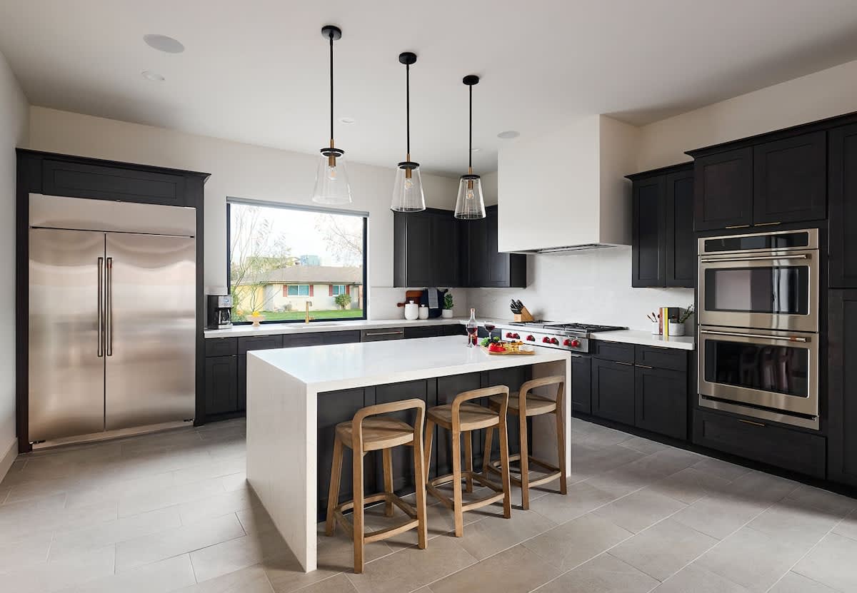 (1st Floor) Fully equipped kitchen with stainless steel appliances, cooking essentials, and kitchen island bar seating.