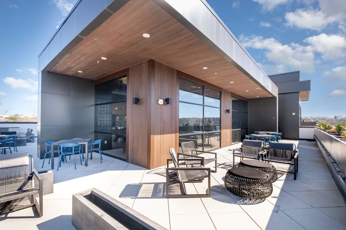 Communal Area: A stylish rooftop lounge area featuring a pool table, multiple dining spaces, and cozy spots to relax and unwind.