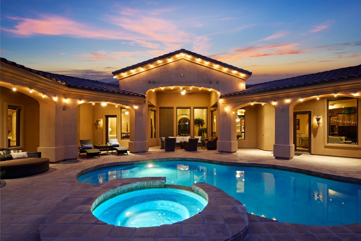 Outdoor oasis featuring a sparkling pool and hot tub. Multiple seating areas, lounge chairs, ping pong table, porch swing, outdoor grill with a built-in burner and mini-fridge, cornhole, putting green