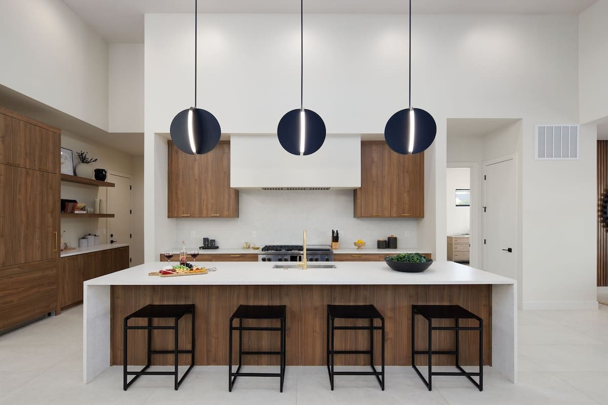 Fully equipped chefs kitchen featuring a colossal kitchen island offering an abundance of counter space with bar seating, high-end stainless steel appliances and stocked with all culinary essentials.