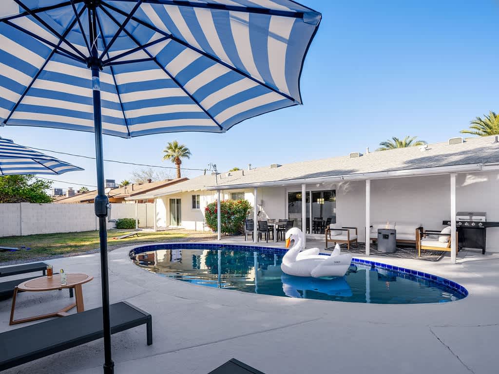 Spacious Entertainers Backyard featuring a Sparkling Blue Pool, Outdoor Furnishings, Fire Pit, and Yard Games