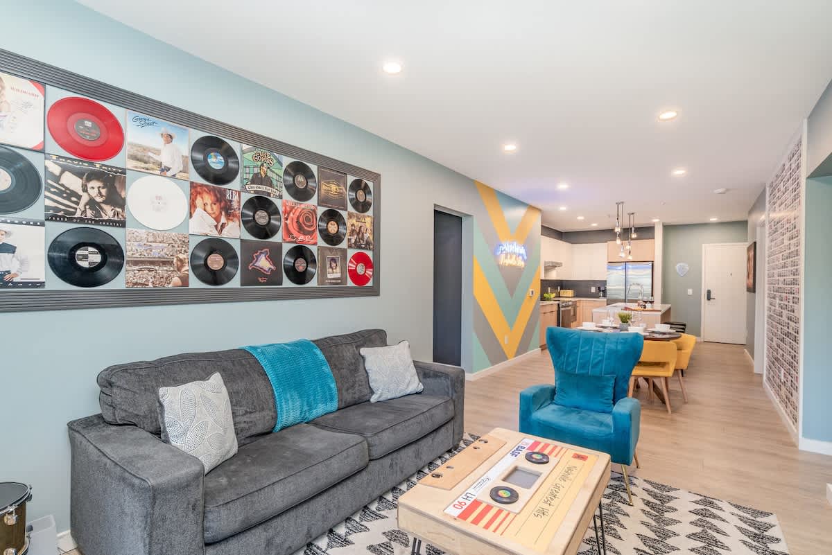Living room with cozy seating, smart TV, and music-inspired décor featuring country album art.