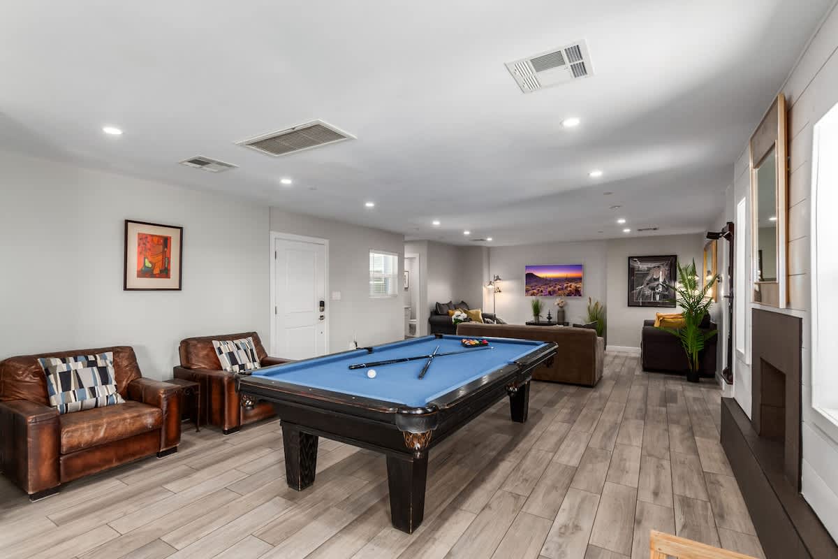 Open-concept living space overlooking the cozy living room featuring a pool table for friendly competition, and a warm fireplace.