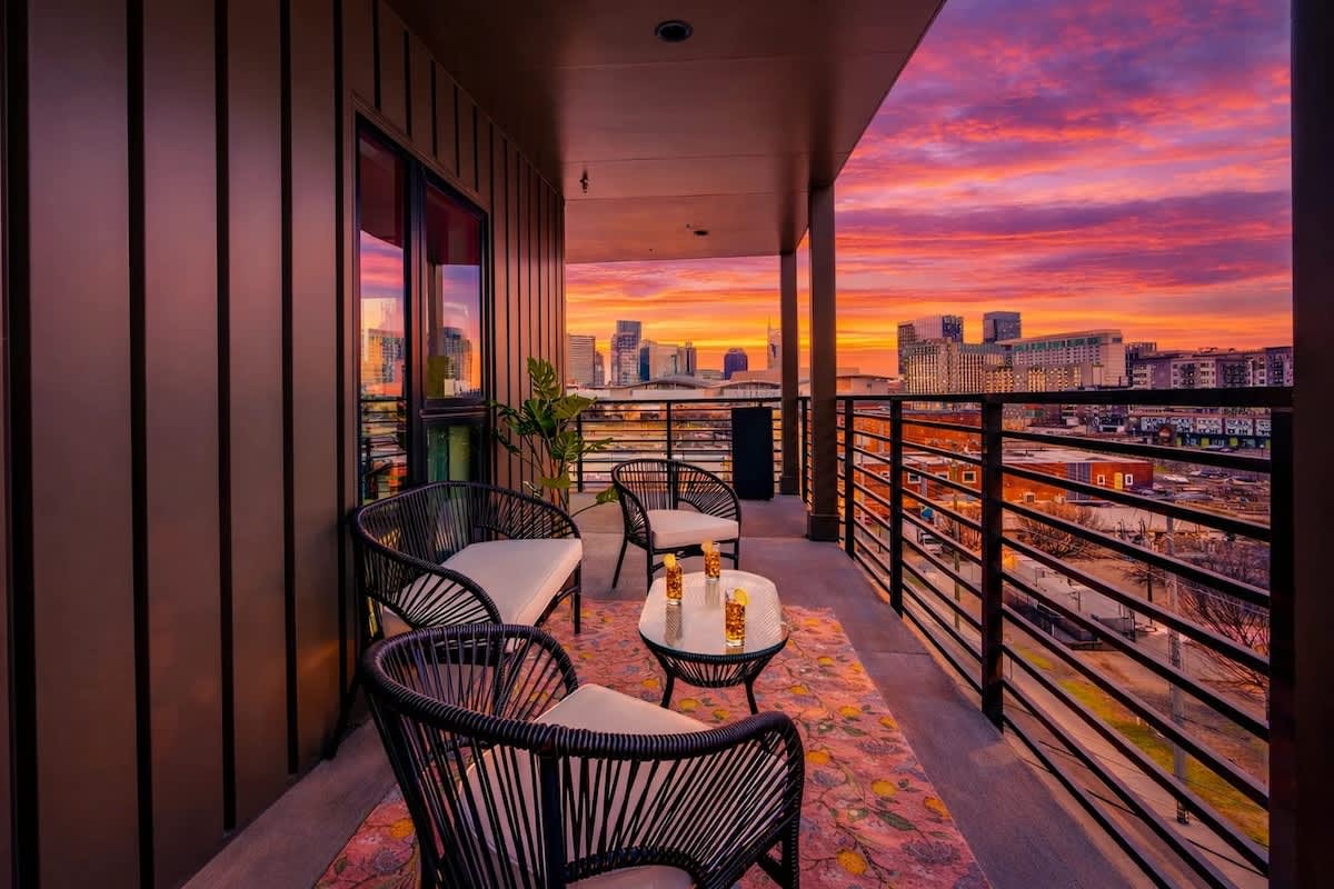 Unit 2: Private Corner Balcony offering outdoor furnishings for lounging and dining accompanied by the beautiful Nashville Cityscape.