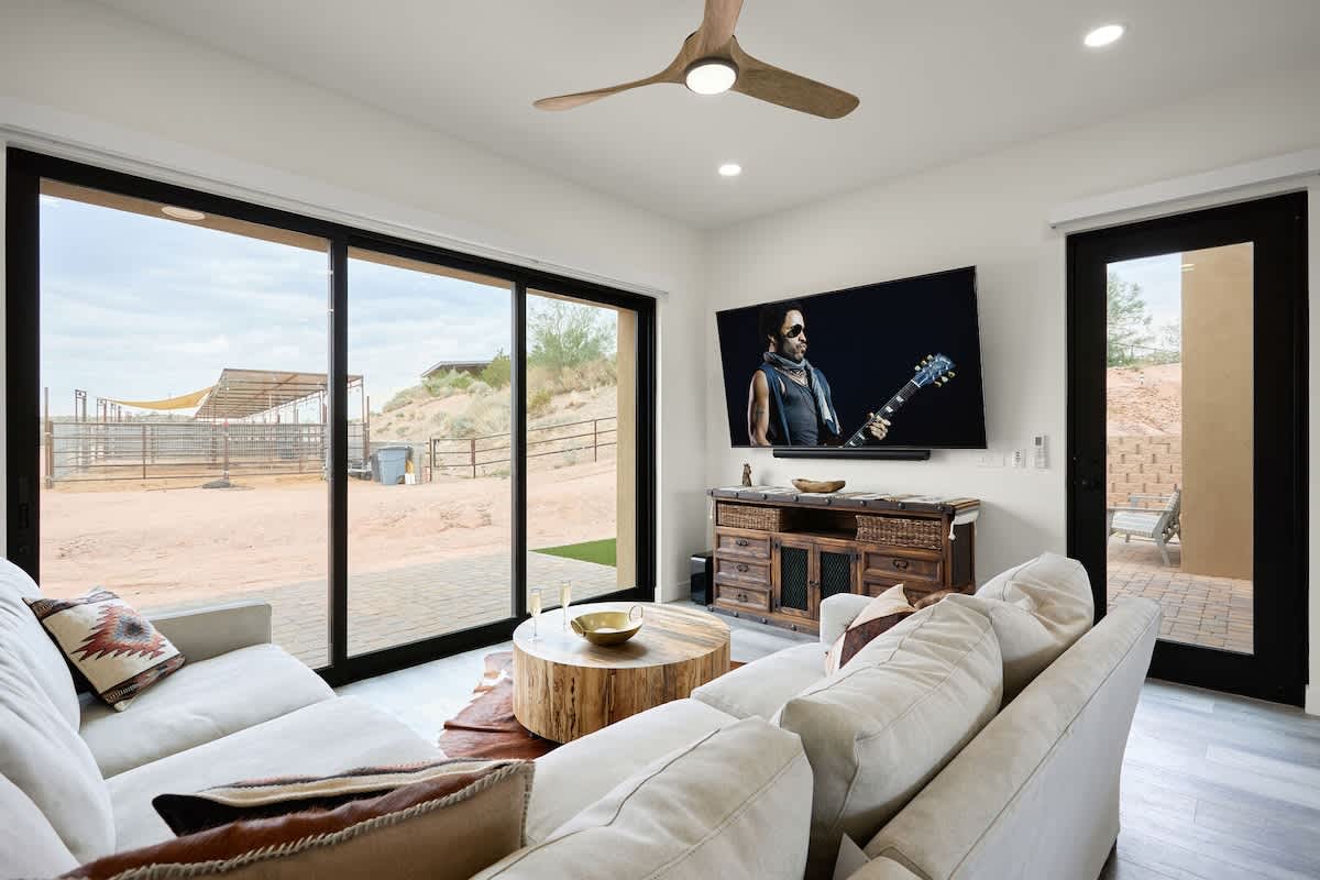 Bright open living area, modern furnishings, smart TV, and easy access to the kitchen area and access to the private patio.