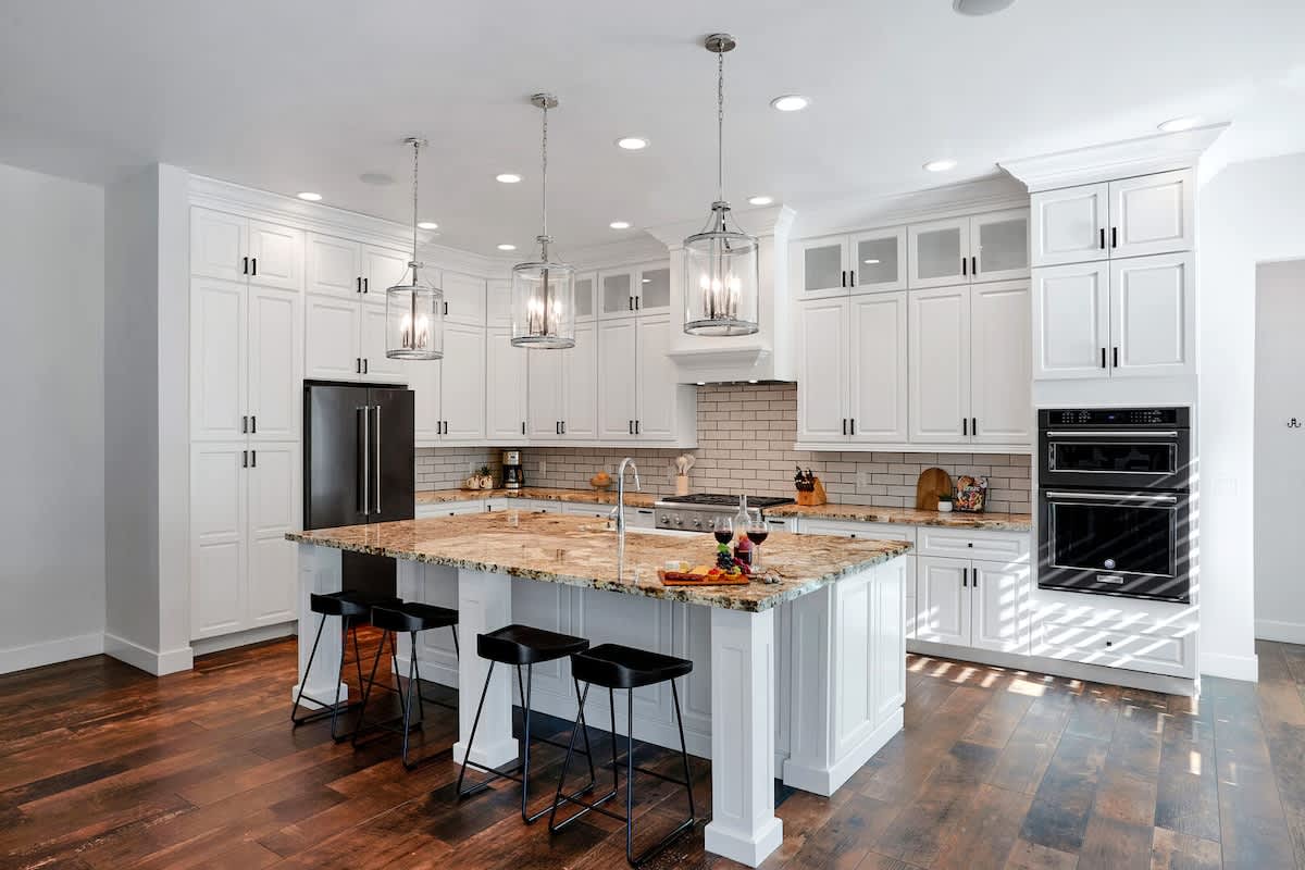 The kitchen offers a bright, spacious layout with ample cabinetry, stainless steel appliances, and a center island with seating for 4.