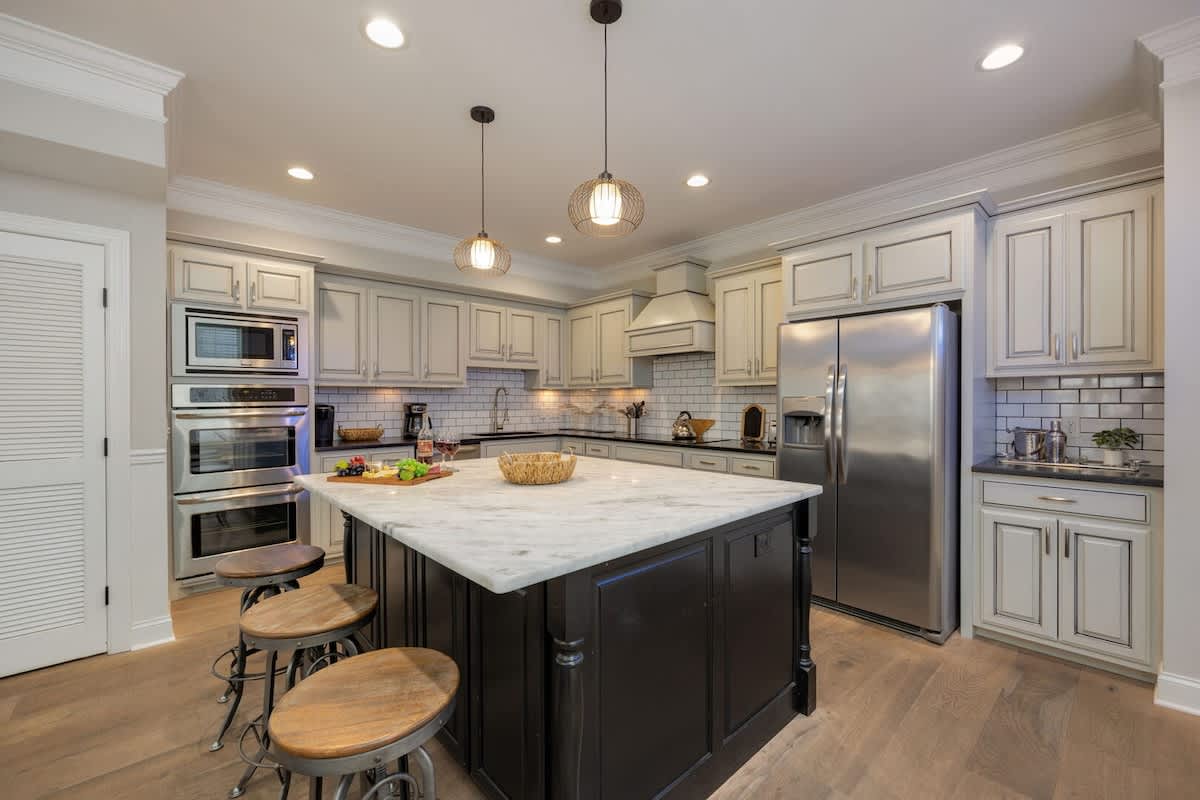 2nd Floor: Fully-equipped kitchen with stainless steel appliances, basic cooking essentials, a large island with bar seating, and wet bar.