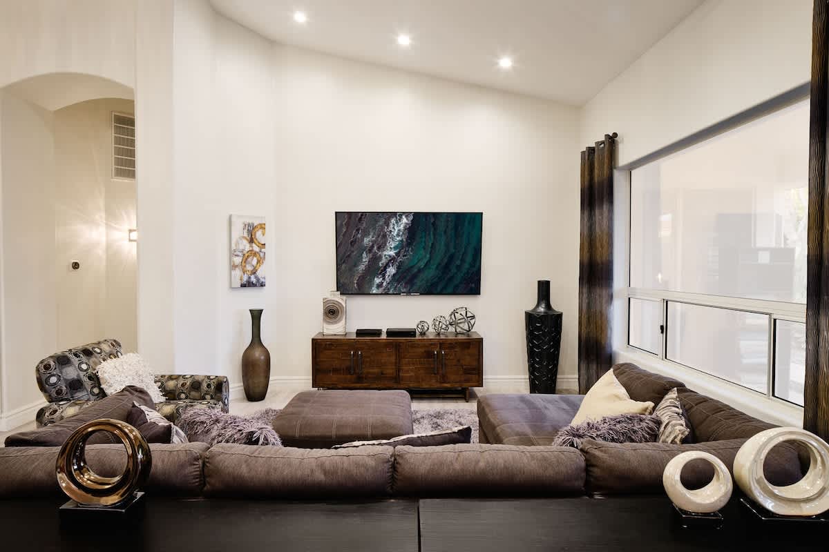 Cozy open spaced living room with smart tv, work station, and foosball table.