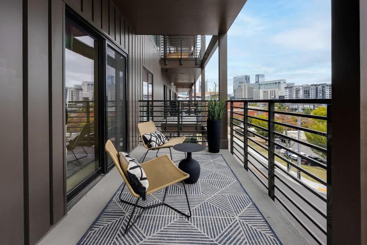 Balcony / Patio accessible through the living room and 2nd bedroom featuring outdoor furnishings for dining and lounging accompanied with city views.