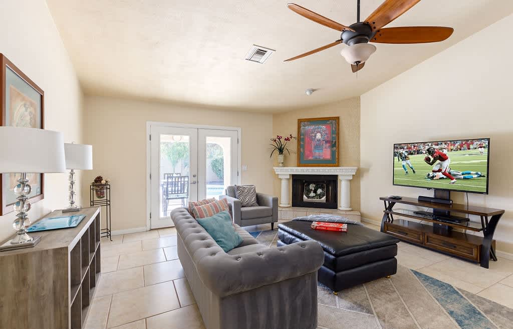 Main living area with designer furnishings, smart TV, and a fireplace.