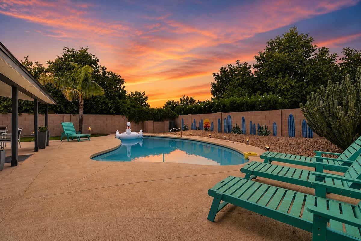 Private backyard with a sparkling pool, sun loungers, a covered patio with outdoor seating surrounding the fire pit and an outdoor dining area, plus a gazebo with a BBQ grill and a putting green.