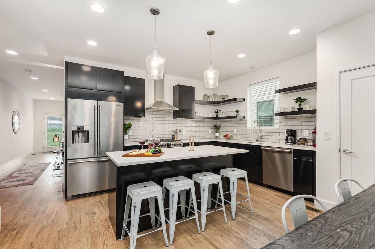 Unit 1: Fully Equipped Kitchen with stainless steal appliances, bar seating, and a dining area.