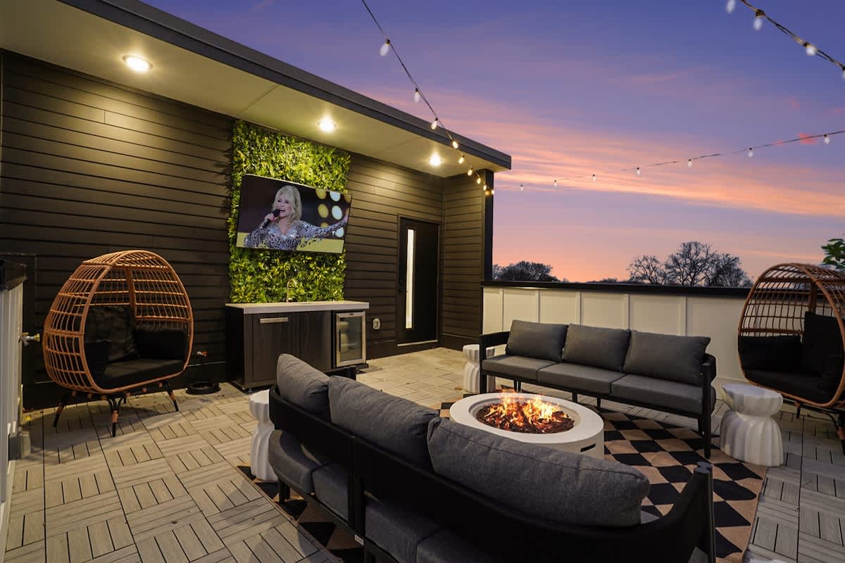 4th Floor: Rooftop patio featuring a lounge area surrounding a fire pit, outdoor seating, outdoor dining area, smart TV, and a wet bar with a mini fridge.