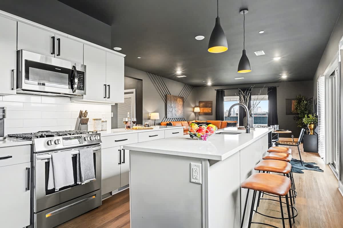 Fully equipped kitchen, complete with stainless-steel appliances and a kitchen island with ample counter space and bar seating.