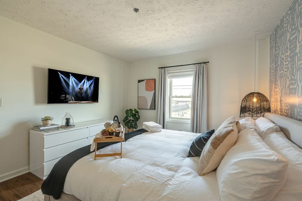 Primary bedroom with King bed, designer furnishings, smart TV, and en-suite bathroom.