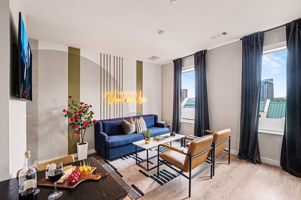 Bright and open living area featuring a smart TV and plush furnishings. Connects to the dining area and kitchen.