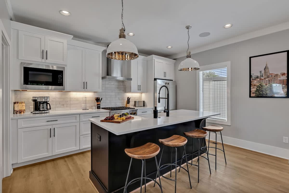 Unit 1 - 2nd Floor: Fully equipped kitchen, complete with all essential culinary tools, boasts stainless-steel appliances and a spacious island with ample counter space and bar seating.