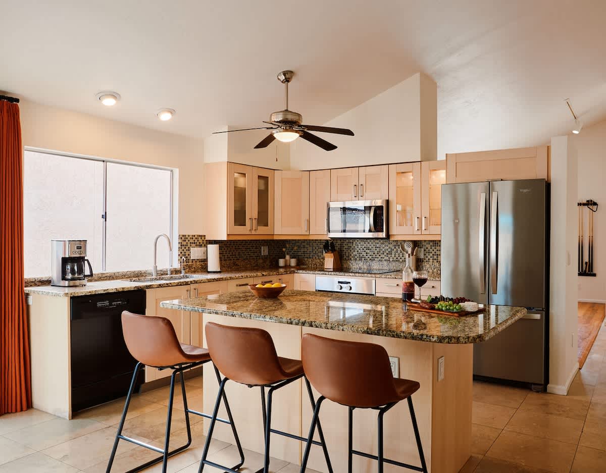 Fully equipped kitchen with stainless steal appliances and a kitchen island with bar seating for 3 guests.