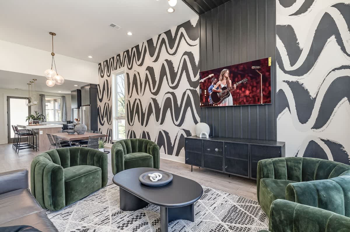 Unit 2: (1st Floor) A modern, trendy living room adorned in designer furnishings and decor with sky-high ceilings, large windows, and a smart TV.