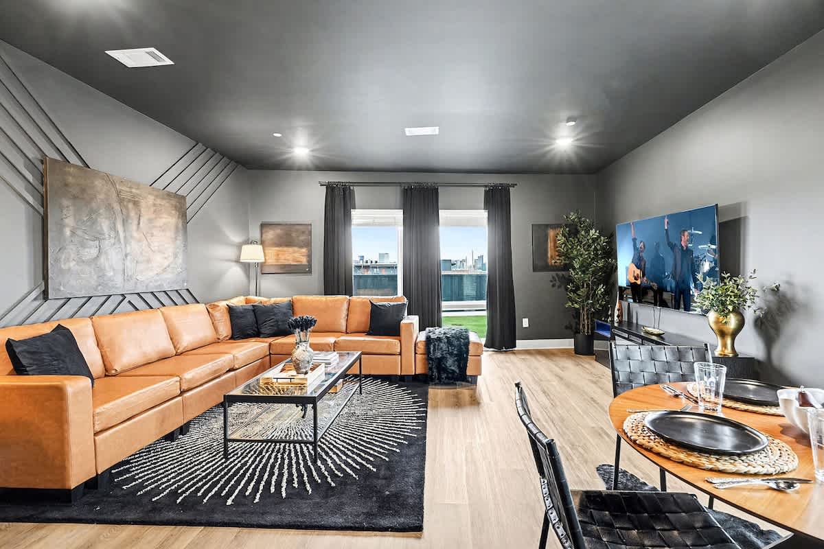 Bright and open concept living area with plush furnishings and a modern design that flows effortlessly into the dining area and open kitchen.