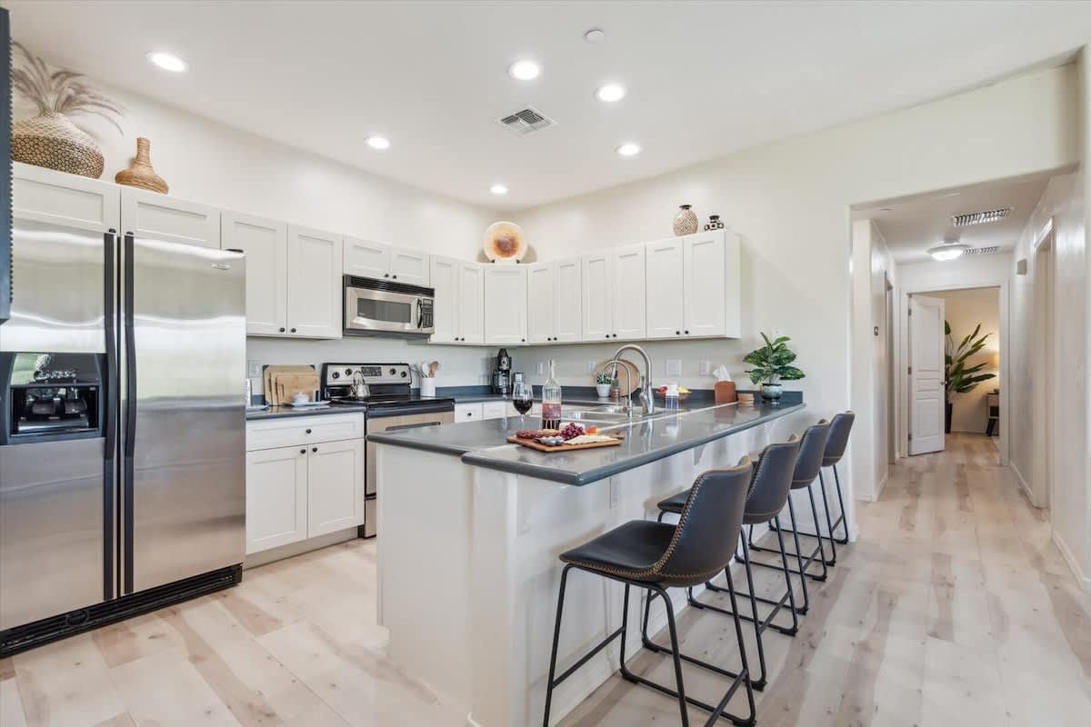 The Kitchen showcases a clean look, stainless steel appliances, and bar seating for four in a stylish, functional layout.