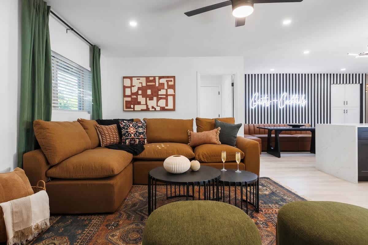 2nd living area with a smart TV, gas fireplace, designer sectional, comfy chairs, breakfast table, and private access to the patio.
