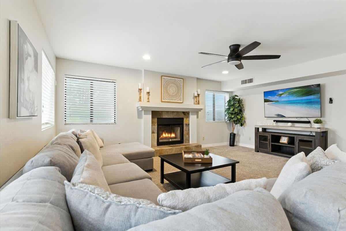 The secondary living area offers a cozy fireplace, plush sectional, and large Smart TV for the perfect place to relax.