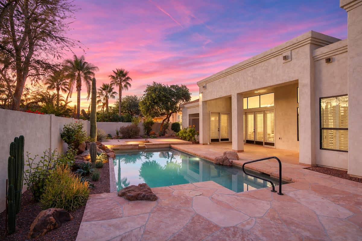 Outdoor sparkling, heated optional pool and hot tub, lounge chairs, outdoor dining table, built-in BBQ grill, and outdoor seating.
