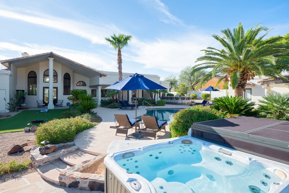 Resort style backyard with private pool, hot tub, lounge chairs, outdoor dining, corn hole, built in grill and fire pit!