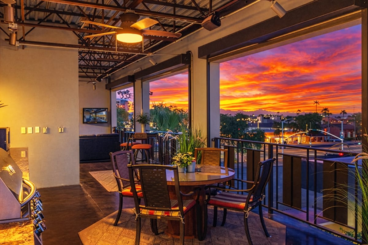 Rooftop deck boasts an outdoor kitchen with grill, sink, mini fridge, and cooking utensils, outdoor dining for four, a fireplace, smart TV, and three furnished lounging areas, and breathtaking panoram