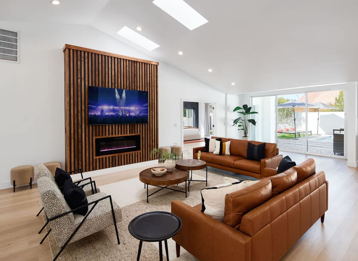 Large and Spacious contemporary living space featuring high ceilings, an electric fireplace, a Smart TV and designer furnishings.