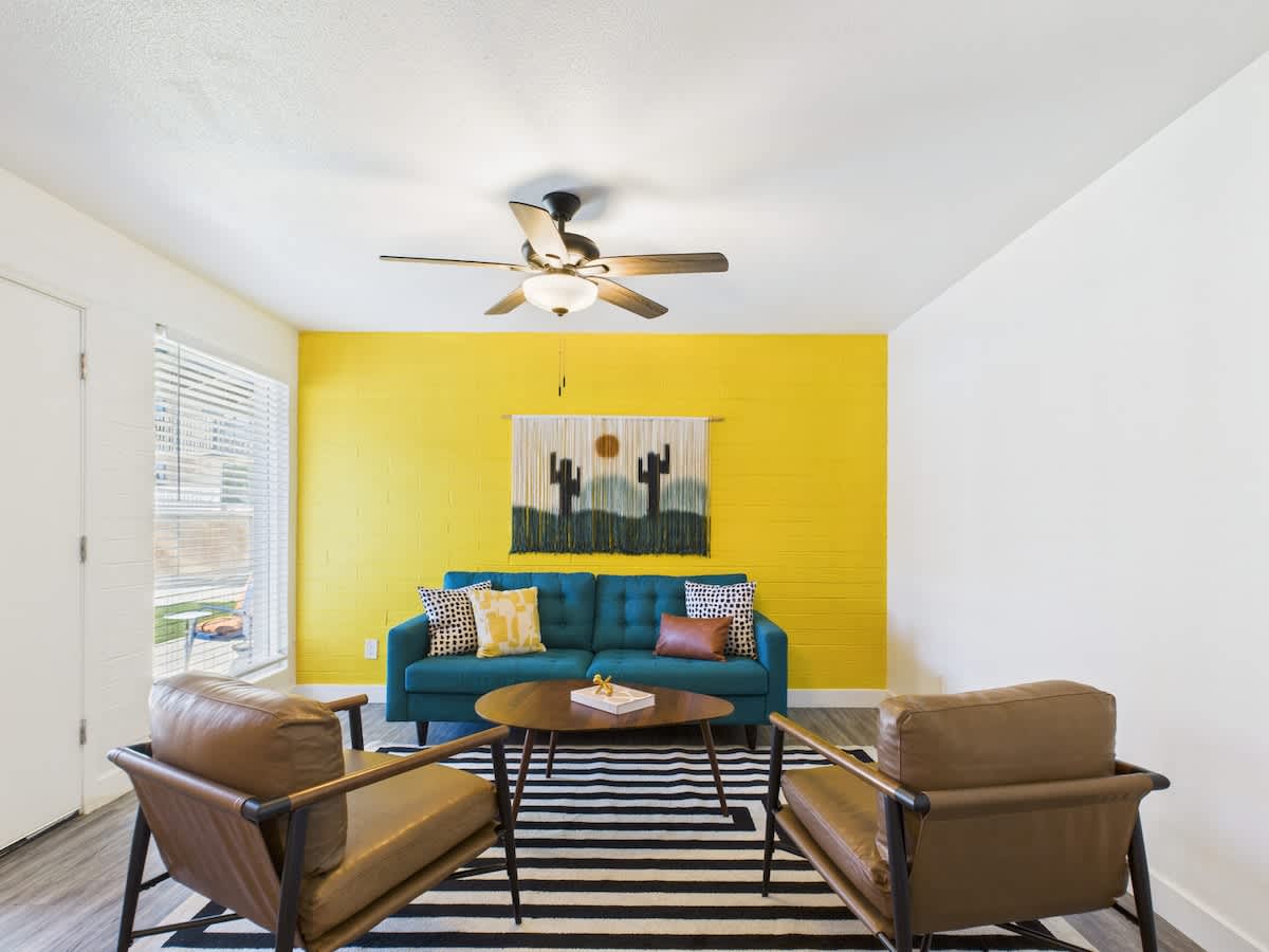 Bright and open living area featuring a smart TV, designer furnishings, and a dining table that seats 2 guests.
