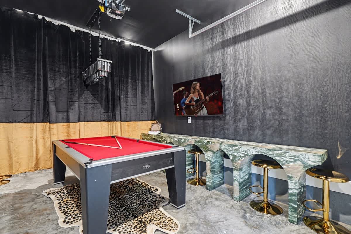 Stylish game room featuring a pool table, smart TV, and bar seating for 4 guests.