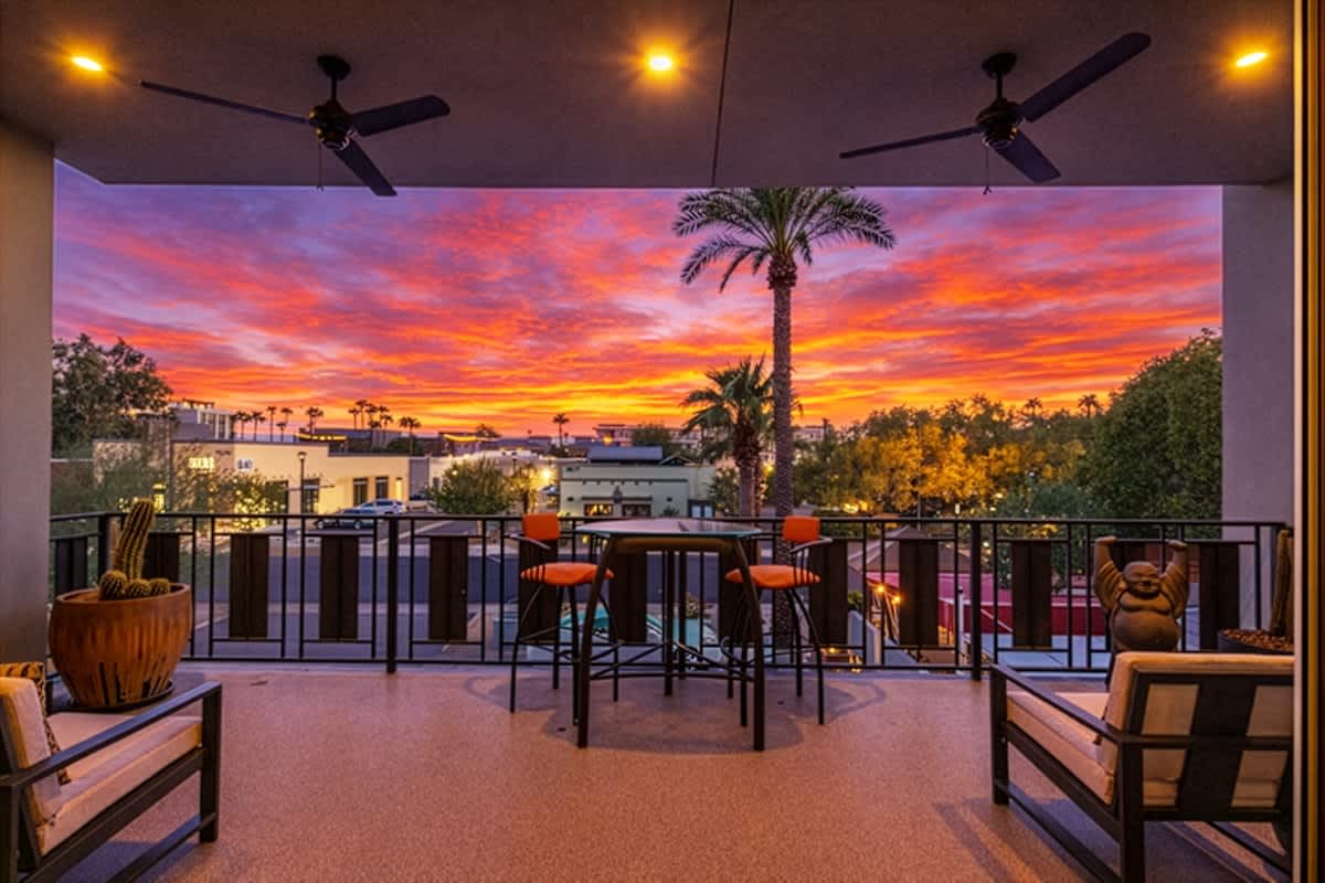 Spacious patio offers an outdoor dining table for two, additional seating, ambient lighting and ceiling fans, all with stunning downtown Scottsdale views.