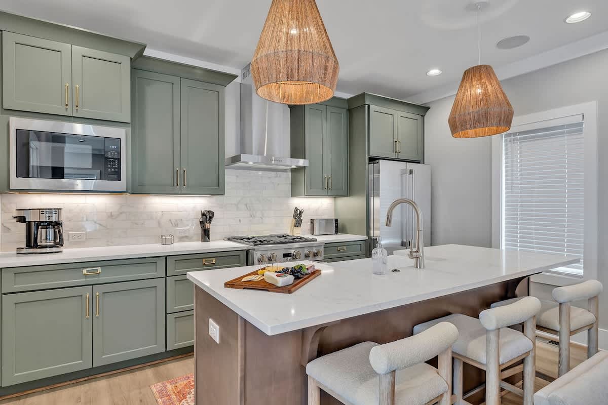 2nd Floor: Fully equipped kitchen stocked with all culinary essentials featuring stainless-steel appliances and a kitchen island offering ample counter space and bar seating.