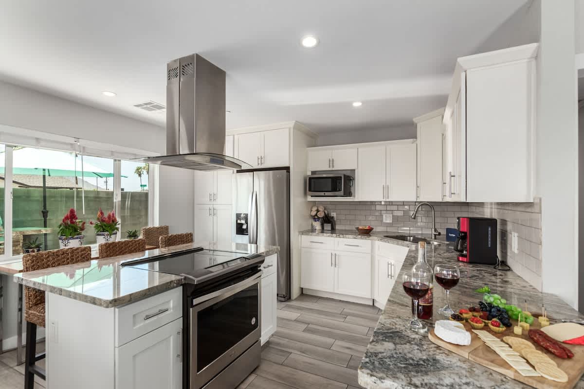 Fully equipped kitchen boasting stainless-steel appliances, and an island with bar seating. Stocked with all culinary essentials for ease and convenience during your stay.