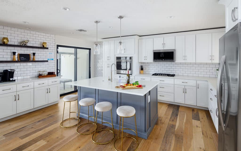 Fully equipped kitchen with stainless steel appliances, coffee bar, breakfast bar seating, and filled with basic cooking essentials.